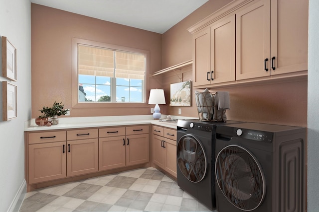 laundry room with washing machine and dryer and cabinets