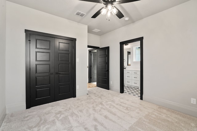 unfurnished bedroom featuring ceiling fan, ensuite bath, light carpet, and a closet