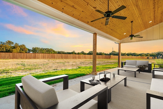 patio terrace at dusk with ceiling fan and an outdoor living space