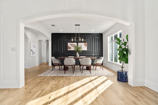 dining room with wood-type flooring and ornamental molding