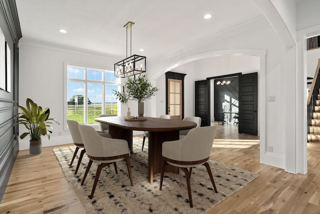 dining room featuring an inviting chandelier, ornamental molding, and light hardwood / wood-style flooring