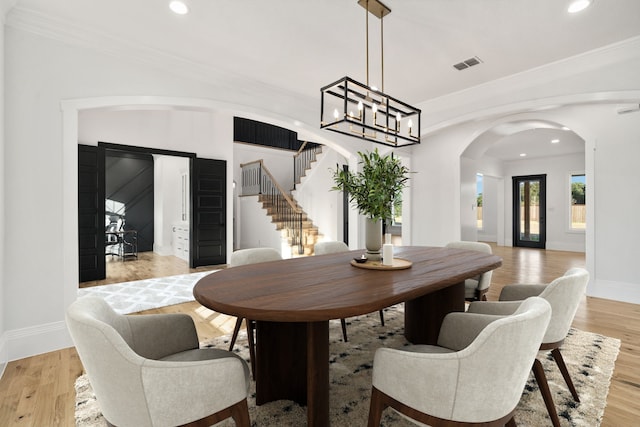 dining space featuring a chandelier, crown molding, and light hardwood / wood-style flooring