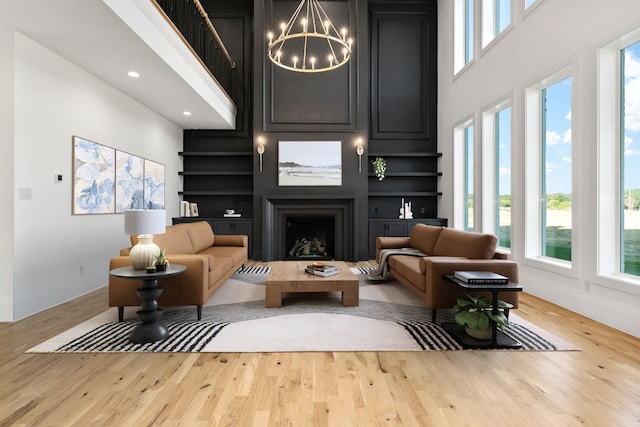 living room with a fireplace, light hardwood / wood-style flooring, and built in features