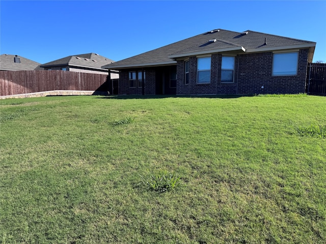 rear view of house featuring a yard