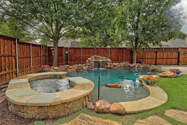 view of pool featuring pool water feature and an in ground hot tub