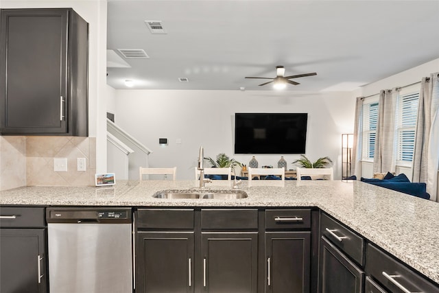 kitchen featuring sink, light stone counters, ceiling fan, dishwasher, and decorative backsplash