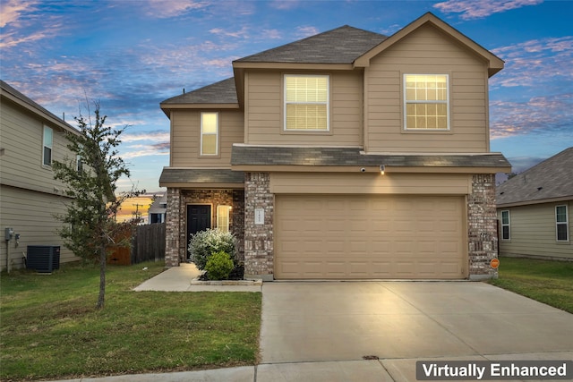 view of front of property featuring a garage, central AC unit, and a lawn