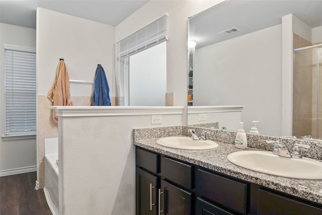 bathroom with wood-type flooring, shower with separate bathtub, and vanity