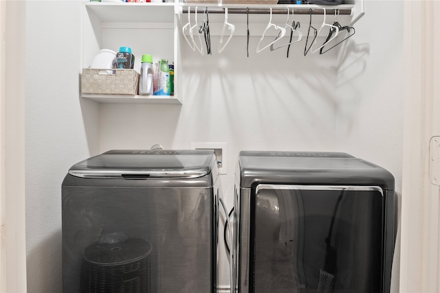 clothes washing area with separate washer and dryer