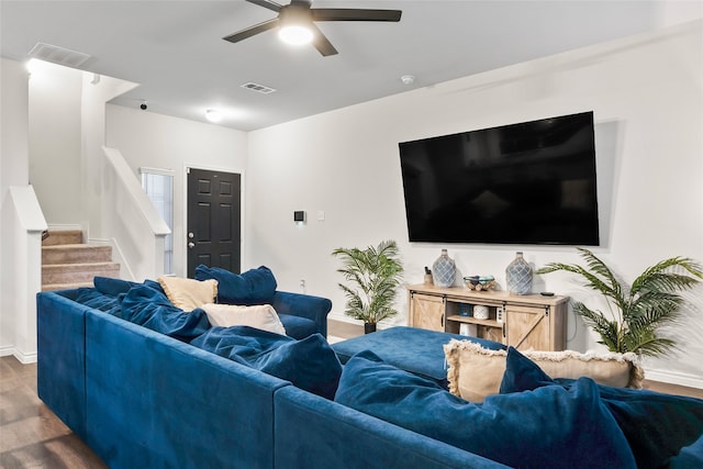 living room featuring ceiling fan and dark hardwood / wood-style floors