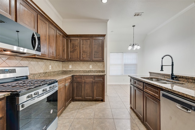 kitchen featuring a notable chandelier, stone countertops, ornamental molding, and appliances with stainless steel finishes