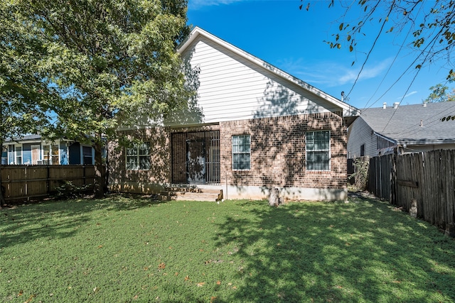 rear view of property with a lawn