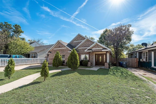 view of front of home with a front yard, fence, and brick siding