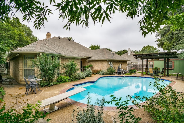 view of pool featuring a patio area, a pergola, and a diving board