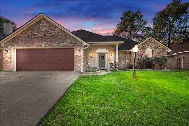 ranch-style house with a garage and a yard