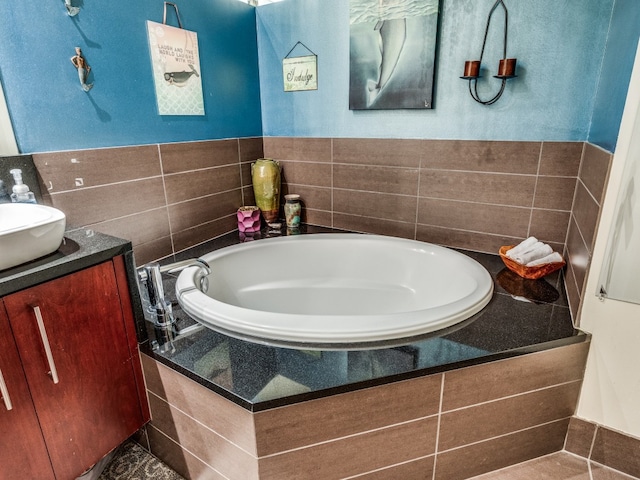 bathroom with tiled tub and vanity