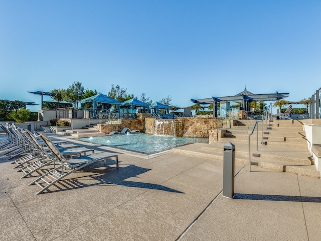 view of swimming pool with pool water feature and a patio