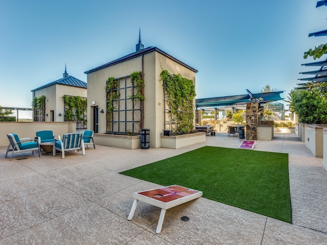 back of house with outdoor lounge area, an outdoor kitchen, a patio area, and a bar