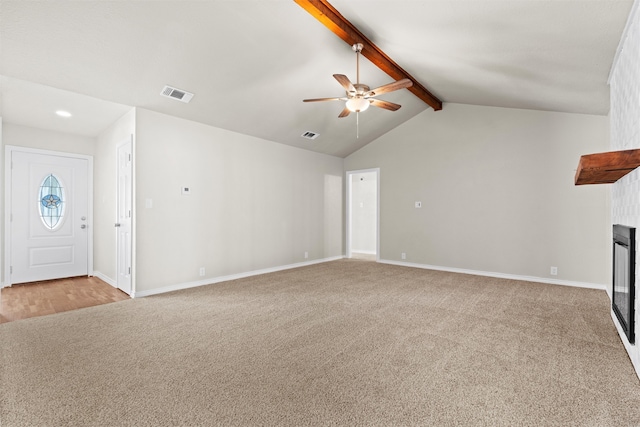 unfurnished living room with ceiling fan, light carpet, a large fireplace, and lofted ceiling with beams