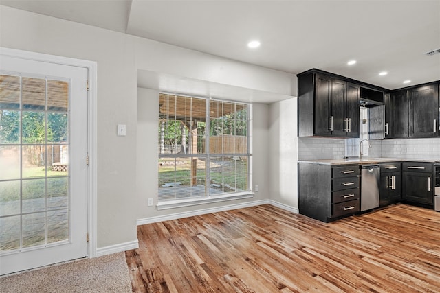 kitchen featuring stainless steel appliances, light hardwood / wood-style flooring, sink, and tasteful backsplash