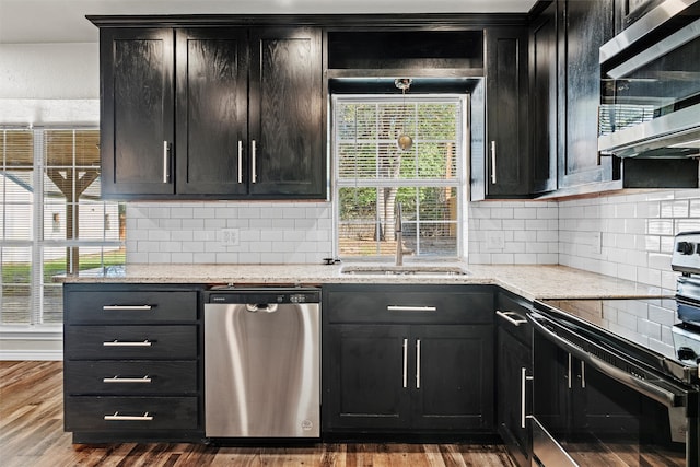 kitchen featuring appliances with stainless steel finishes, sink, light stone counters, and dark hardwood / wood-style floors