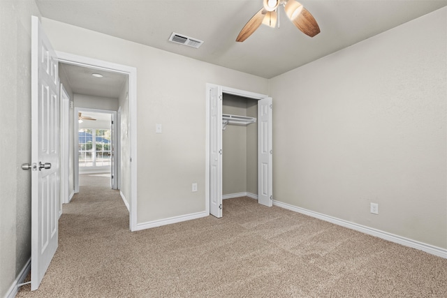 unfurnished bedroom featuring a closet, light carpet, and ceiling fan