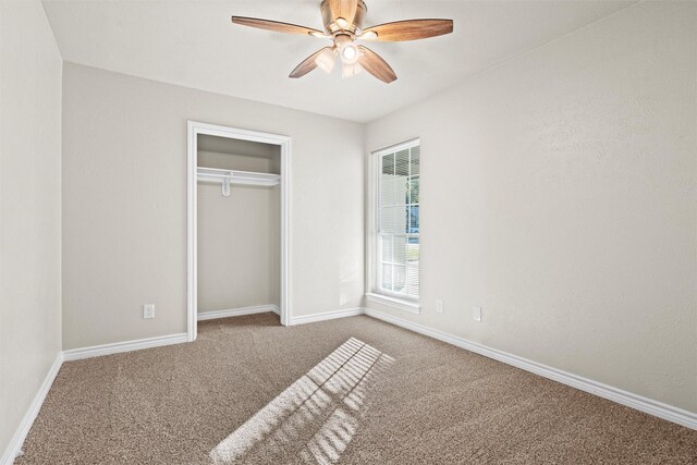 unfurnished bedroom with ceiling fan, a closet, and carpet