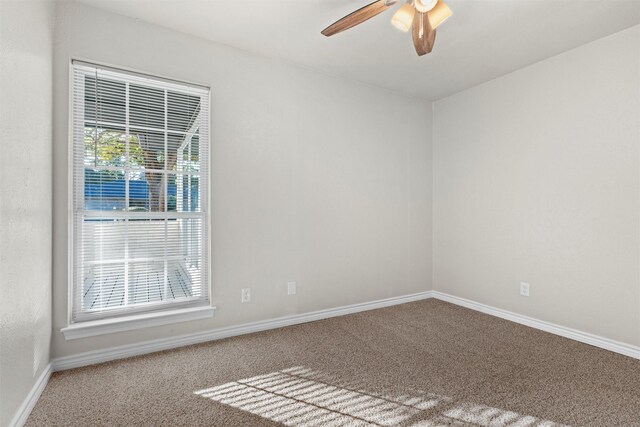 spare room with a wealth of natural light, carpet, and ceiling fan