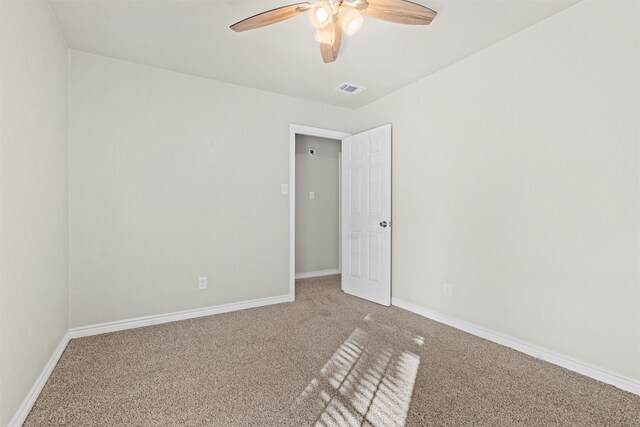 carpeted spare room with ceiling fan