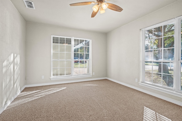 carpeted spare room with a wealth of natural light and ceiling fan