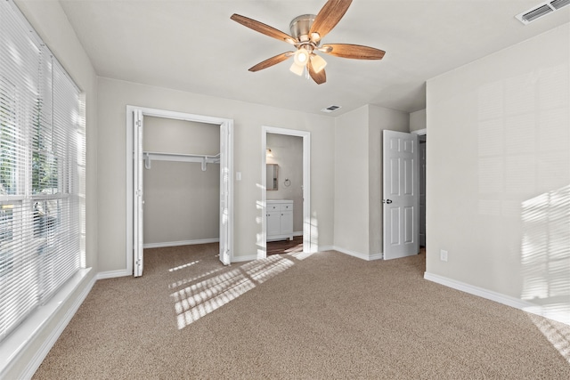 unfurnished bedroom with connected bathroom, a closet, ceiling fan, and carpet floors