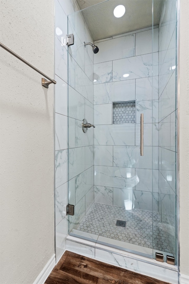 bathroom with hardwood / wood-style floors and a shower with door