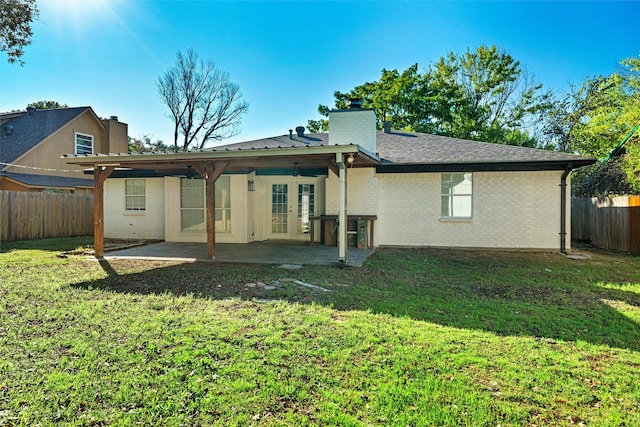 rear view of property featuring a patio and a yard