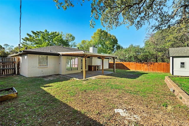 back of property featuring a patio, a yard, and a storage unit