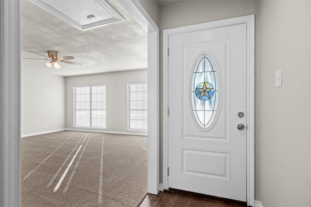 carpeted foyer entrance with a textured ceiling and ceiling fan