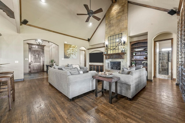 living room featuring beam ceiling, high vaulted ceiling, dark hardwood / wood-style floors, a fireplace, and built in shelves