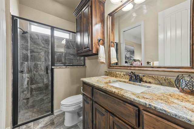 bathroom featuring vanity, toilet, and a shower with shower door