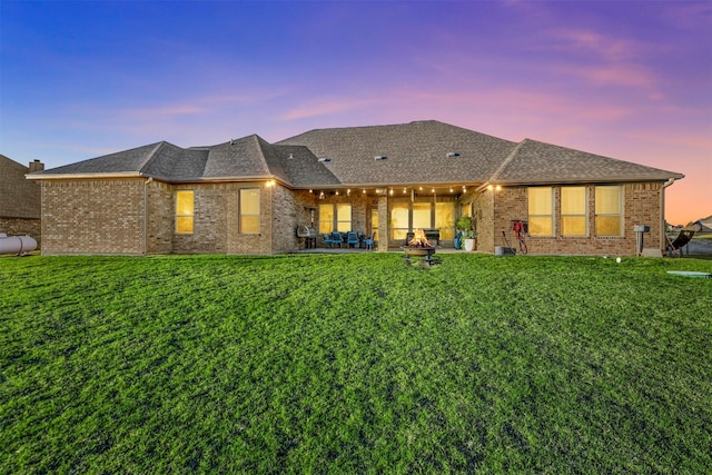13401 Moorhouse Way, Justin, TX 76247 - rear view of property featuring a lawn, brick siding, a patio area, and roof with shingles