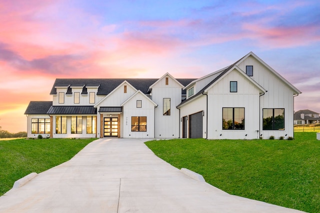 modern inspired farmhouse featuring a garage and a yard