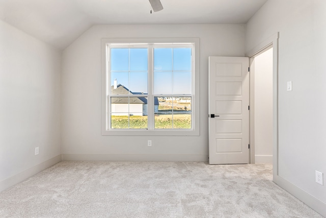 empty room featuring light carpet and vaulted ceiling