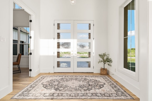 doorway with light hardwood / wood-style floors and french doors