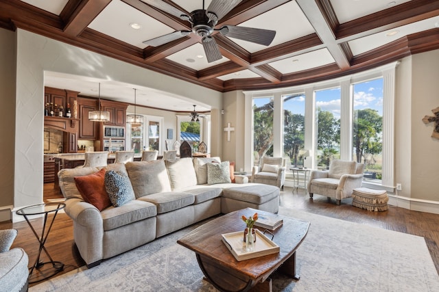 living room featuring beamed ceiling, coffered ceiling, and ornamental molding