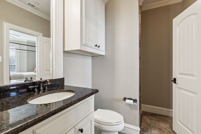 bathroom with tile patterned floors, vanity, toilet, and crown molding