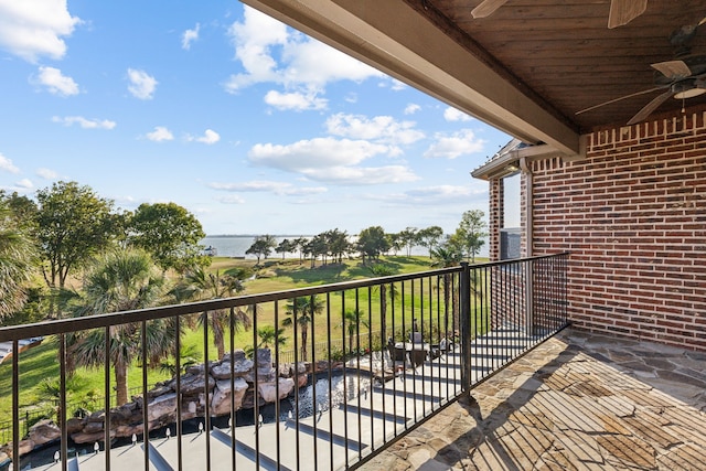 balcony featuring a water view and ceiling fan