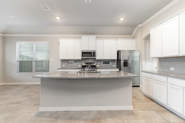 kitchen with stainless steel appliances, white cabinets, a kitchen island with sink, and tasteful backsplash