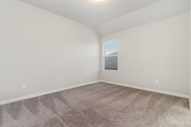 carpeted spare room with lofted ceiling