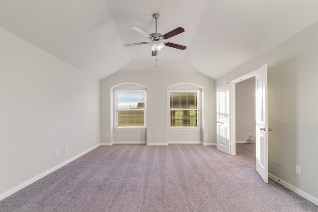 spare room featuring ceiling fan, light carpet, and vaulted ceiling