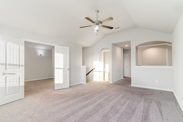 spare room featuring vaulted ceiling, carpet flooring, and ceiling fan