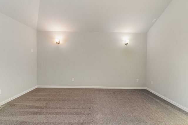 unfurnished room featuring vaulted ceiling and carpet flooring