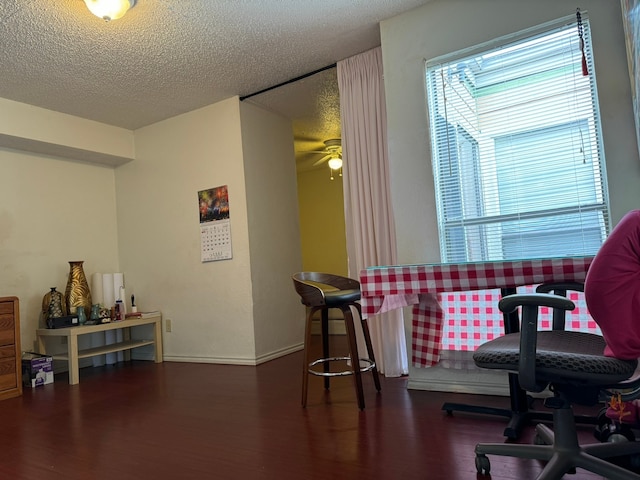 sitting room featuring dark wood-type flooring, ceiling fan, and a textured ceiling